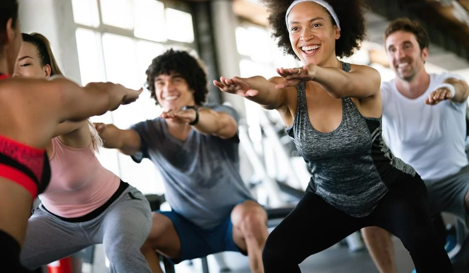 Group of healthy fit people at the gym exercising