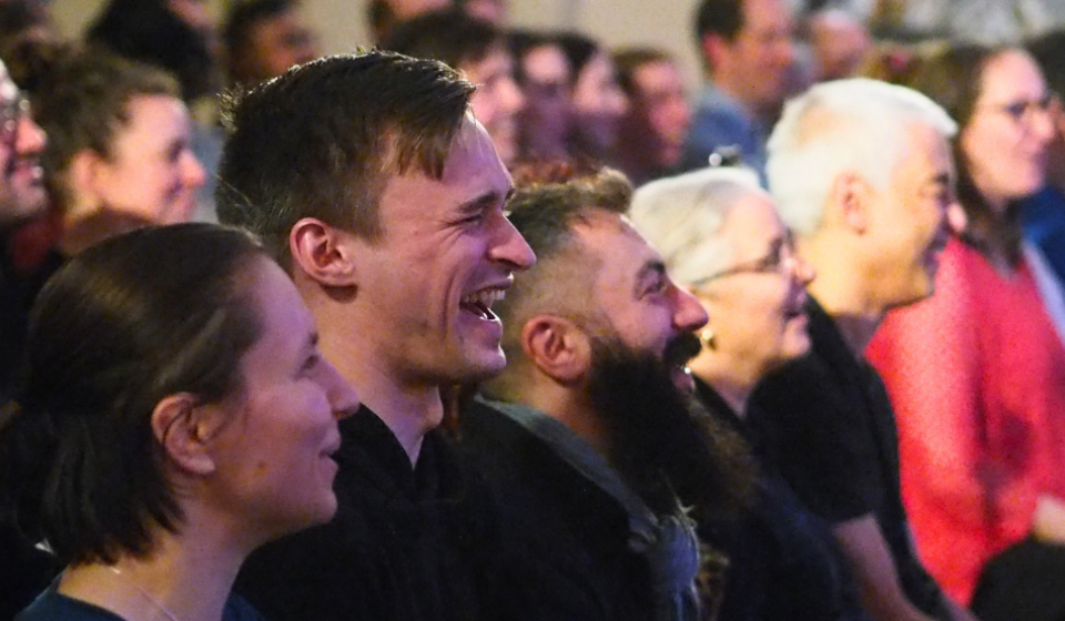 Audience of people laughing.