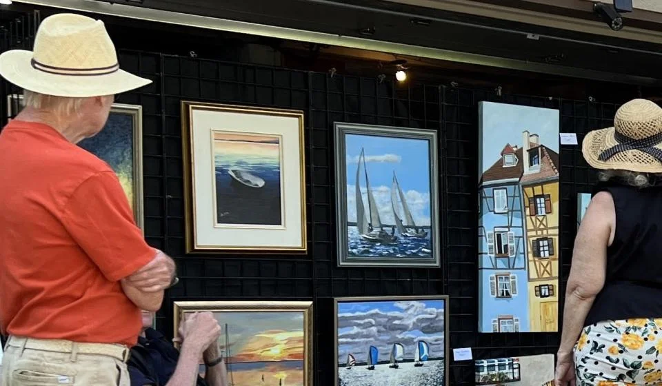 Crowd viewing paintings outdoors