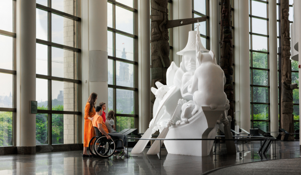 A family (including one wheelchair user) look at a sculpture at the Canadian Museum of History in Ottawa, Canada.