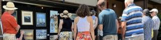 Crowd viewing paintings outdoors