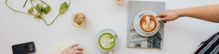 A café table with a latte, matcha and magazines.